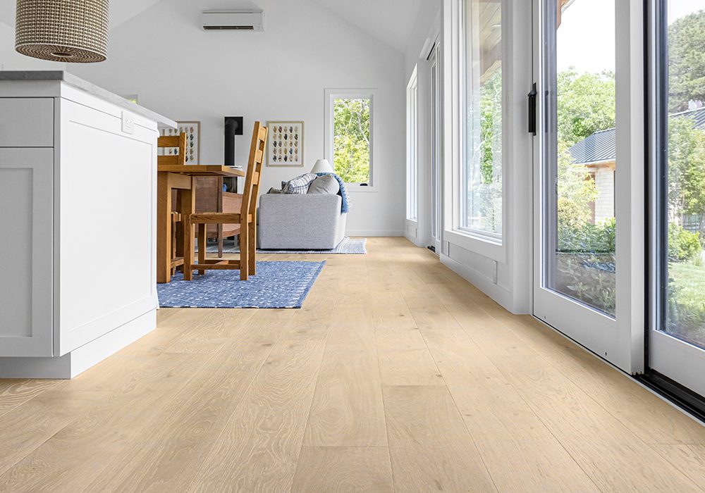 Wide-plank natural oak hardwood flooring with soft window light in a bright room